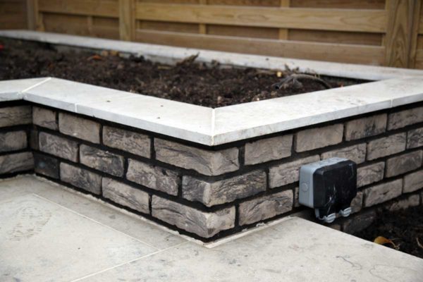 Grey brick raised planter in Forest Gate